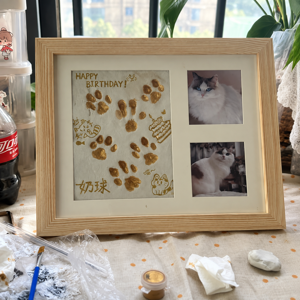Minnesspår i naturträ med målade katttassar och två kattfoton